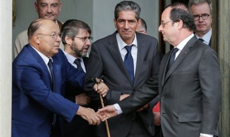 Presiden Prancis Francois Hollande berjabat tangan dengan Pemimpin Masjid Agung Paris Dalil Boubakeur (kiri).