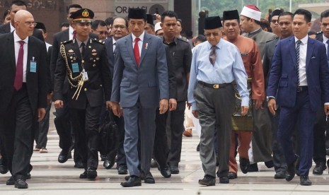 Presiden Republik Indonesia Joko Widodo (ketiga kiri) dan Perdana Menteri Malaysia Tun Dr Mahathir Mohamad (keempat kiri) berjalan bersama ke arah Masjid Putra Putrajaya, Malaysia, Jumat (9/8/2019) untuk melakukan salat Jumat bersama. 