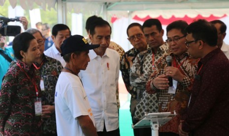 Presiden RI Joko Widodo didampingi Menteri BUMN Rini M. Soemarno memperhatikan penjelasan demo aplikasi Logistik Tani (LOGTAN) dari Direktur Utama Telkom Alex J. Sinaga (kedua dari kanan) saat Peresmian Kewirausahaan Pertanian dan Digitalisasi Sistem Pertanian di Sliyeg Kabupaten Indramayu Jawa Barat, Kamis (7/6).