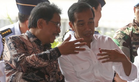 Presiden RI Joko Widodo (kanan) berbincang dengan Menteri (ATR/BPN) Sofyan Djalil (kiri) saat penyerahan sertifikat hak atas lahan tanah di pelataran Benteng Kuto Besak (BKB), Palembang, Sumatera Selatan, Jumat (13/7).