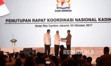 Presiden RI Joko Widodo (kanan), menerima buku rekomendasi hasil Rakornas Kadin 2017 dari Ketum Kadin Rosan Roslaeni (tengah), didampingi Ketua Panitia Rakornas Maruarar Sirait saat Penutupan Rakornas Kadin 2017, Jakarta, Selasa (3/10).