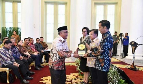 Presiden RI Joko Widodo menyerahkan penghargaan Anugerah Dana Rakca 2017 dari Kementerian Keuangan RI kepada Wali Kota Depok Mohammad Idris di Istana Bogor, Rabu (6/12).