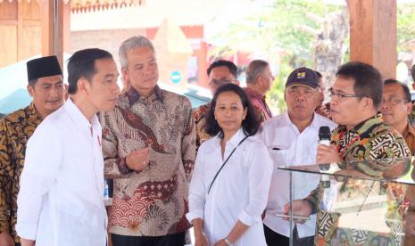 Presiden RI Joko Widodo (paling kiri) didampingi Menteri BUMN Rini M. Soemarno (ketiga dari kiri), Menteri PUPR Basuki Hadimuljono (kedua dari kanan), dan Gubernur Jawa Tengah Ganjar Pranowo (kedua dari kiri) saat mendengarkan penjelasan Direktur Utama Telkom Alex J. Sinaga (paling kanan) mengenai Balai Ekonomi Desa (Balkondes) Tuksongo yang dibangun oleh Telkom Indonesia di Desa Tuksongo, Kecamatan Borobudur, Kabupaten Magelang, Senin (18/8). 