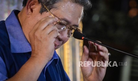 Presiden keenam RI yang juga Ketua Umum Partai Demokrat Susilo Bambang Yudhoyono (SBY) memakai kacamatanya sebelum memberikan pemaparan saat menggelar jumpa pers di kediamannya, Puri Cikeas, Kabupaten Bogor, Jawa Barat, Rabu (2/11).