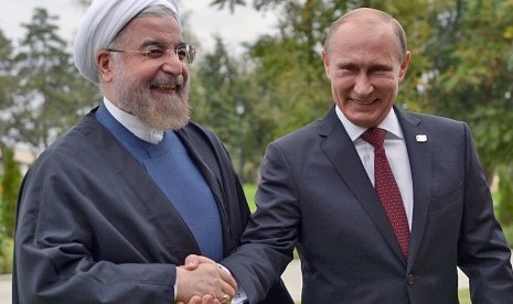 Presiden Rusia Vladimir Putin bersalaman dengan Presiden Iran Hassan Rouhani.