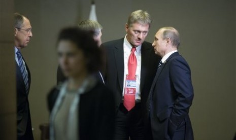 Presiden Rusia Vladimir Putin (kanan) berbicara dengan  juru bicara Kremlin Dmitry Peskov (kedua kanan) dalam KTT G-20 di Antalya, Turki, Senin, 16 November 2015.