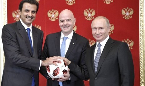 Presiden Rusia Vladimir Putin (kanan), Presiden FIFA Gianni Infantino (tengah) dan Emir Qatar, Sheikh Tamim bin Hamad al-Thani berfoto dalam pertemuan di Kremlin, Moskow, Rusia, Ahad (15/7).