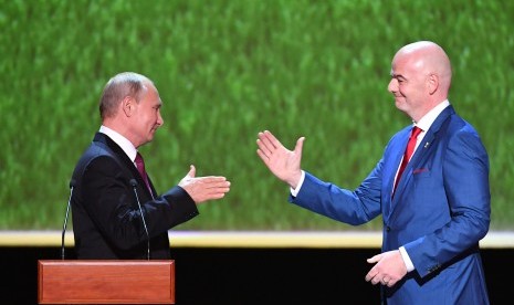 Presiden Rusia Vladimir Putin (kiri) berjabat tangan dengan Presiden FIFA Gianni Infantino (R) sebelum konser bintang opera dunia di Teater Bolshoi Akademik Negara di Moskow, Rusia, 14 Juli 2018. 