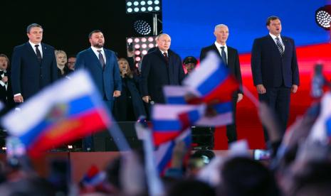 Presiden Rusia Vladimir Putin, tengah, berbicara sementara Leonid Pasechnik, pemimpin Republik Rakyat Luhansk yang memproklamirkan diri, kiri, Denis Pushilin, pemimpin Republik Rakyat Donetsk yang memproklamirkan diri, kedua kiri, kepala Wilayah Kherson yang ditunjuk Moskow Vladimir Saldo, kedua kanan, dan kepala wilayah Zaporizhzhia yang ditunjuk Moskow Yevgeny Balitsky, kanan, berdiri di dekatnya selama perayaan menandai penggabungan wilayah Ukraina untuk bergabung dengan Rusia di Lapangan Merah di Moskow, Rusia, Jumat, 30 September 2022. Penandatanganan perjanjian-perjanjian yang menjadikan keempat wilayah itu sebagai bagian dari Rusia mengikuti penyelesaian 