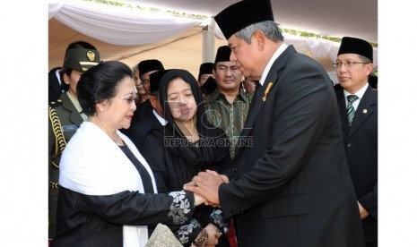 Presiden Susilo Bambang Yudhoyono (kanan) menyalami  Presiden RI ke-5 Megawati Soekarnoputri (kiri) yang juga istri mendiang Ketua MPR Taufiq Kiemas saat pemakaman di Taman Makam Pahlawan Kalibata, Jakarta, Ahad (9/6).  (Antara/Setpres)