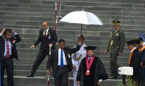 Presiden Susilo Bambang Yudhoyono (ketiga kanan) didampingi Wapres Boediono (kanan) bergegas saat jeda penyampaian pidato pengukuhan Guru Besar pada Sidang Senat Terbuka Akademik Universitas Pertahanan Indonesia karena gerimis