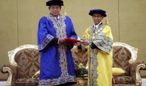 Presiden Susilo Bambang Yudhoyono (kiri) menerima gelar Doktor Honoris Causa (HC) atas kontribusinya untuk kepemimpinan dalam perdamaian dari Universitas Utara Malaysia (UUM) yang diberikan Yang Dipertuan Agong Abdul Halim Mu'adzam Shah (kanan) selaku Cons