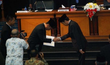 Presiden terpilih, Joko Widodo (kanan) memberikan surat pengenduran diri kepada Ketua DPRD DKI, Prasetyo Edi Marsudi (kiri) di ruang sidang paripurna Gedung DPRD DKI, Jakarta Pusat, Kamis (2/10). (Republika/Raisan Al Farisi)