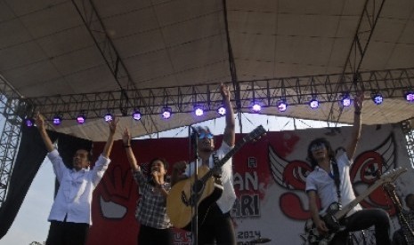 Presiden terpilih Joko Widodo (kiri) naik ke panggung bersama grup musik Slank dan penyanyi Oppie Andaresta dalam Konser 