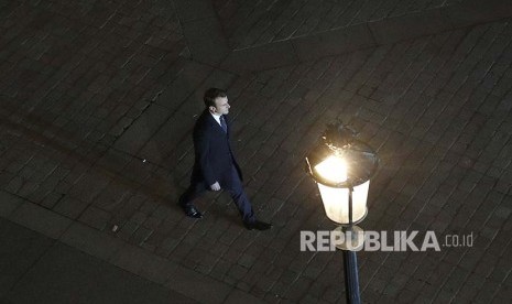 Presiden terpilih Perancis Emmanuel Macron berjalan menuju podium dalam acara perayaan kemenangan di depan Museum Louvre. 