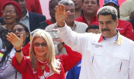 Presiden Venezuela Nicolas Maduro dan istri Cilia Flores melambaikan tangan kepada pendukungnya di luar istana kepresidenan Miraflores di Caracas, Venezuel, Senin (20/5). 