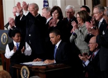 Presiden Barack Obama disambut tepuk tangan usai meneken UU Kesehatan di Gedung Putih, Washington pada 23 Maret 2010 lalu. 