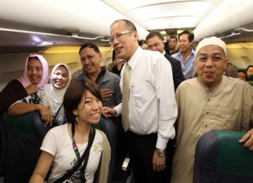 Presiden Filipina, Ninoy Aquino, berfoto bersama penumpang di maskapai Cebu Airlines.