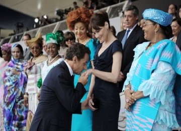 Presiden Prancis, Nicolas Sarkozy, mencium tangan istrinya, Carla Bruni, pada peringatan Hari Bastille di Paris.