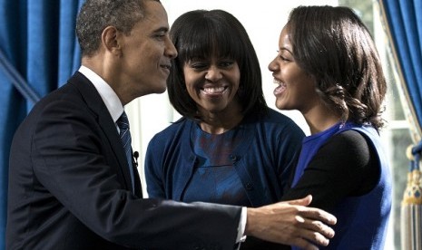 President Barack Obama embraces daughter Malia as first lady Michelle Obama watches after Obama was officially sworn-in by Chief Justice John Roberts, not pictured, in the Blue Room of the White House during the 57th Presidential Inauguration in Washington, Sunday, Jan. 20, 2013. 