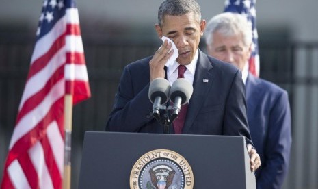 President Barack Obama wipes his face as he speaks during a 9/11 rememberance ceremony at the Pentagon, Wednesday, Septer 11, 2013.