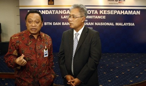 President director of Bank Tabungan Negara Maryono (left) talks with Datuk Adinan Maning, his counterpart from Malaysian's Bank Simpanan Nasional. Both sides secure agreement to develop remittance service, last week. (file photo)