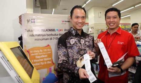 President Director PT Modern Putra Indonesia, Henri Honoris dan Vice President Postpaid Marketing, Derrick Heng, saat melakukan penukaran Telkomsel Poin di kiosk Sevelin, Jakarta, Senin (14/7).