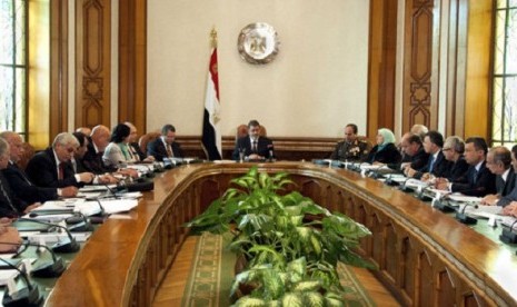 President Mohammed Morsi, center, meets with his cabinet including 10 new ministers after their swearing in at the presidential palace in Cairo, Egypt, Sunday Jan. 6, 2013.   