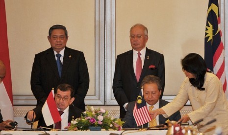 President Susilo Bambang Yudhoyono (left) and Malaysia's Prime Minister Najib Tun Razak witness the signing ceremony between Indonesian Minister of Social affairs Salim Segaf al Jufri (front left) and his counterpart, Anifah Aman, on Tuesday in Putrajaya, 