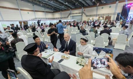 Pria asal Italia, Luca, bersama pasangannya saat melangsungkan pernikahan di JCC, Senayan, dalam perayaan Hari Amal Bhakti Kementerian Agama, Jumat (5/1/2024). 