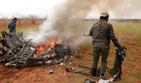 Bangkai helikopter tentara Suriah yang ditembak jatuh di Desa Qaminas, sebelah timur Idlib, Suriah utara, Selasa (11/2). Suriah bertekad merebut kembali Idlib yang kini dikuasai kubu pemberontak.