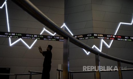 Pria memotret dengan latar pergerakan Indeks Harga Saham Gabungan (IHSG) di BEI, Jakarta, Jumat (24/2).  IHSG akhir pekan ditutup menguat 13,15 poin (0,24 persen) ke level 5.385 setelah bergerak di antara 5.370-5.391.