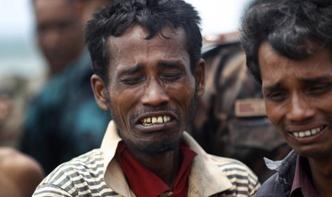  Pria muslim Rohingya menangis ketika dipaksa untuk naik kapal untuk dikembalikan ke Myanmar dekat pos penjaga perbatasan di Taknaf,Bangladesh,Jumat (22/6).  (Saurabh Das/AP)