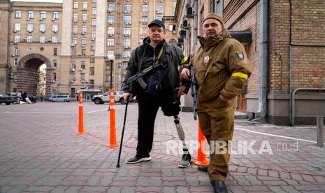  Pria pertahanan sipil bersenjata berpose untuk foto saat berpatroli di jalan kosong karena jam malam di Kyiv, Ukraina, Ahad, 27 Februari 2022. Pihak berwenang Ukraina mengatakan bahwa pasukan Rusia telah memasuki kota terbesar kedua di Ukraina, Kharkiv. Pasukan Rusia juga meningkatkan tekanan pada pelabuhan strategis di selatan negara itu menyusul gelombang serangan terhadap lapangan terbang dan fasilitas bahan bakar di tempat lain yang tampaknya menandai fase baru invasi Rusia.