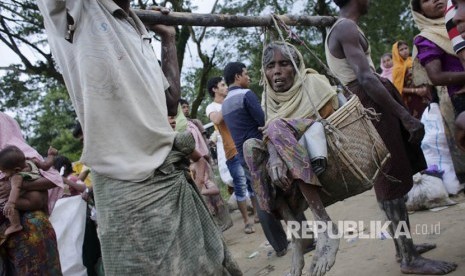 Pria Rohingya membawa ibu mereka yang sakit saat mereka tiba di perbatasan Bangladesh di Teknaf, Bangladesh, Sabtu (9/9). 