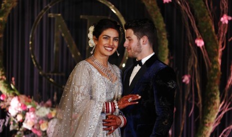 Priyanka Chopra dan Nick Jonas berpose untuk fotografer di resepsi pernikahan mereka di New Delhi, Selasa (4/12/2018). Usia keduanya terpaut 10 tahun.