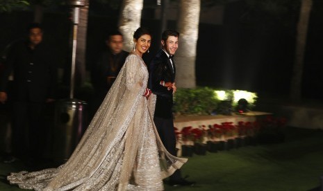 Priyanka Chopra dan Nick Jonas berpose untuk fotografer di resepsi pernikahan mereka di New Delhi, Selasa (4/12).