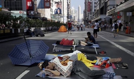 Pro-democracy protesters sleep in a main road in the occupied areas in Hong Kong's Mong Kok district Saturday, Oct. 11, 2014. 