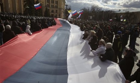 Pro-Russia demonstrators chant slogans as they carry a giant flag during a rally at a central square in Kharkiv, Ukraine, on Sunday March 16, 2014.