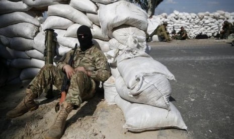 Pro-Russian separatist fighters from the so-called Battalion Vostok (East) wait behind sandbag walls at a checkpoint on the outskirts of the eastern Ukrainian city of Donetsk, July 10, 2014.