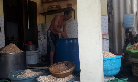 Produsen tempe di Surabaya, Untung Sutopo (49) memilah kacang kedelai sebagai bahan baku pembuatan tempe di kediamannya di Jalan Tenggilis Kauman, Tenggilis Mejoyo, Surabaya, Selasa (10/7).