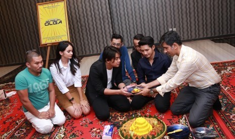 Produser film Warisan Olga Gophe Samtani (kanan) memberikan potongan tumpeng kepada adik almarhum Olga Syahputra, Billy Syahputra (tengah) disaksikan pemain film Warisan Olga di Jakarta , Senin (13/7).