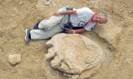 Profesor Shinobu Ishigaki berpose di dekat jejak kaki terbesar dinosaurus 