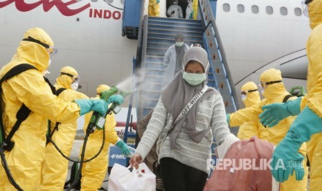 Proses evakuasi WNI dari Wuhan disemprot cairan desinfektan sesaat setelah turun dari pesawat Boeing A330-300 Batik Air di Bandara Internasional Hang Nadim Batam, Ahad (2/2).