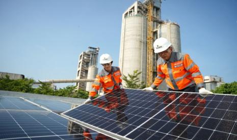 Proses pemasangan panel surya di atap gedung utama kantor PT Solusi Bangun Indonesia Tbk (SBI) Pabrik Tuban, Jawa Timur.