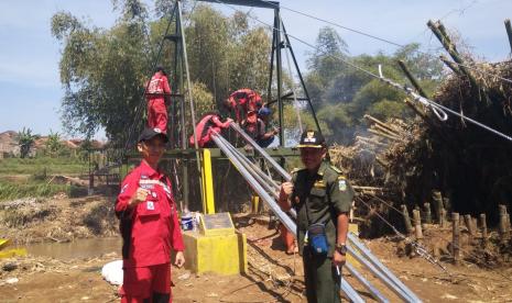 Proses pembangunan jembatan darurat di Desa Sukasenang, Kecamatan Banyuresmi, Kabupaten Garut. BPBD Garut mengatakan warga terdampak bencana di Garut akan direlokasi ke tanah desa.