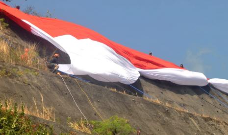 Prosesi pembentangan bendar Merah Putih berukuran 17 x 45 meter di tebing bukit Galepek, Kelurahan Sidomulyo, Kecamatan Ungaran Timur, Kabupaten Semarang, Jawa Tengah, Rabu (17/8). Kegiatan ini dilaksanakan untuk memeriahkan HUT Kemerdekaan RI ke-77.  