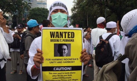 Protester was holding a poster saying that Jakarta (inactive) Governor Basuki Tjahaja Purnama has harmed Indonesia unity and harmony.