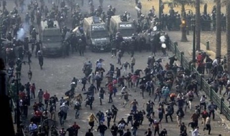 Protesters run from the riot police during clashes at Tahrir square in Cairo November 25, 2012. On Friday, President Mohamed Mursi had issued a decree widening his powers and shielding them from judicial review.  