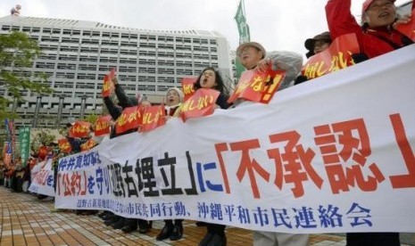 Protesters shout slogans during a rally against the relocation of a US military base, in front of the Okinawa prefectural government office building, in Naha on the Japanese southern islands of Okinawa, in this photo taken by Kyodo December 27, 2013.